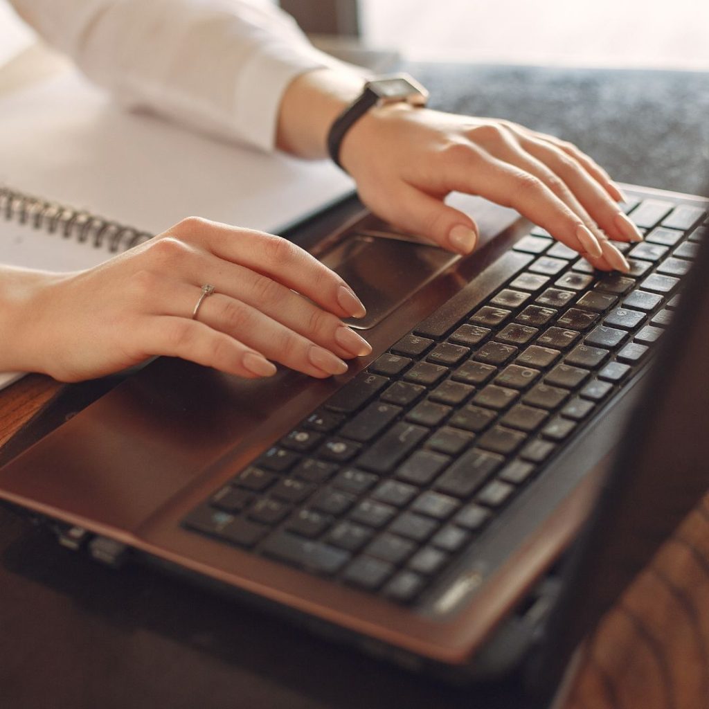 hands typing on laptop